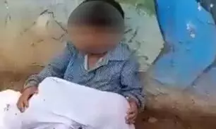8-yr-old boy sits with younger brothers body in lap outside hospital as father looks for ambulance 8-yr-old boy sits with younger brothers body in lap outside hospital as father looks for ambulance