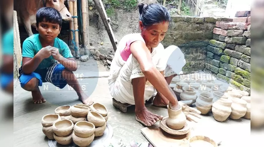 AT Photo: A woman crafting clay pots