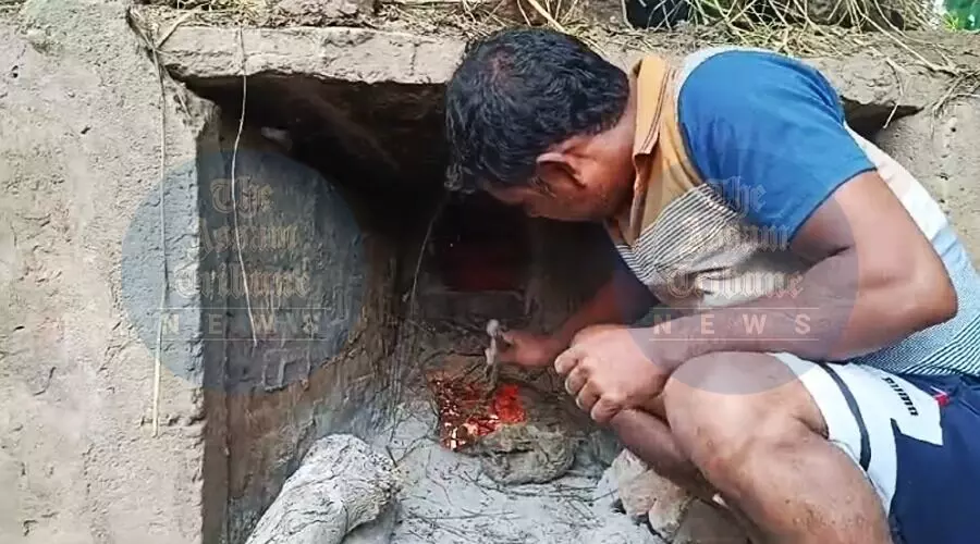 AT Photo: A man refining the clay products with fire