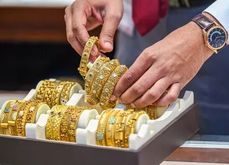 Gold prices climb from 1-week low amid weaker dollar, festive demand